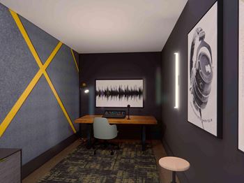 A room with a desk, chair, and a picture of a camera on the wall.